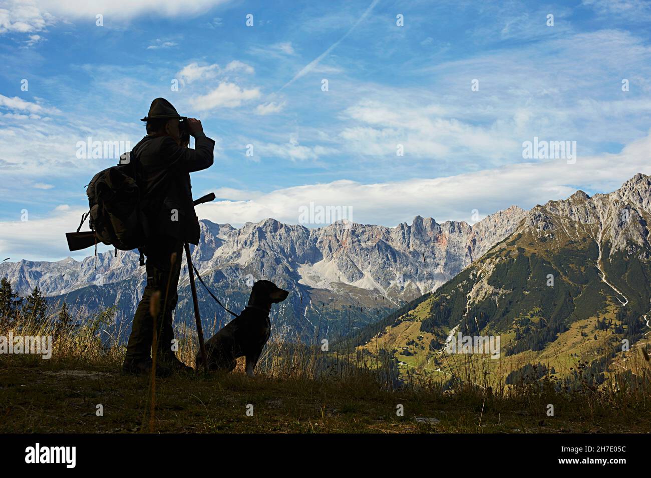 Un cacciatore con un cane in un ambiente di montagna Foto Stock