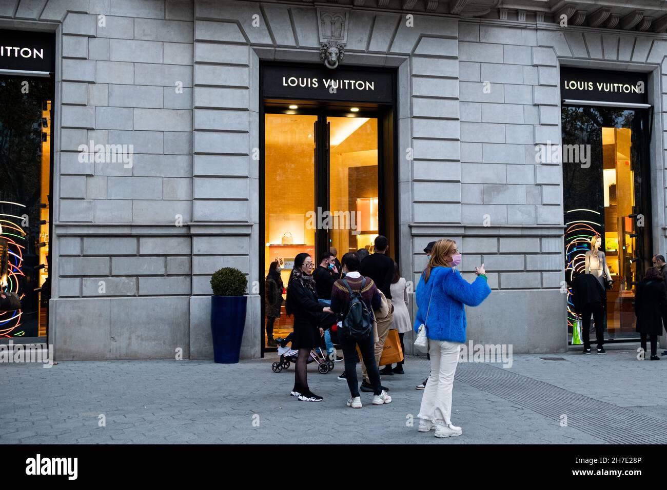 La gente si trova di fronte a un negozio di moda Louis Vuitton nella via  Passeig de Gracia, nella parte alta di Barcellona, in Spagna, il 20  novembre 2021. (Foto di Davide