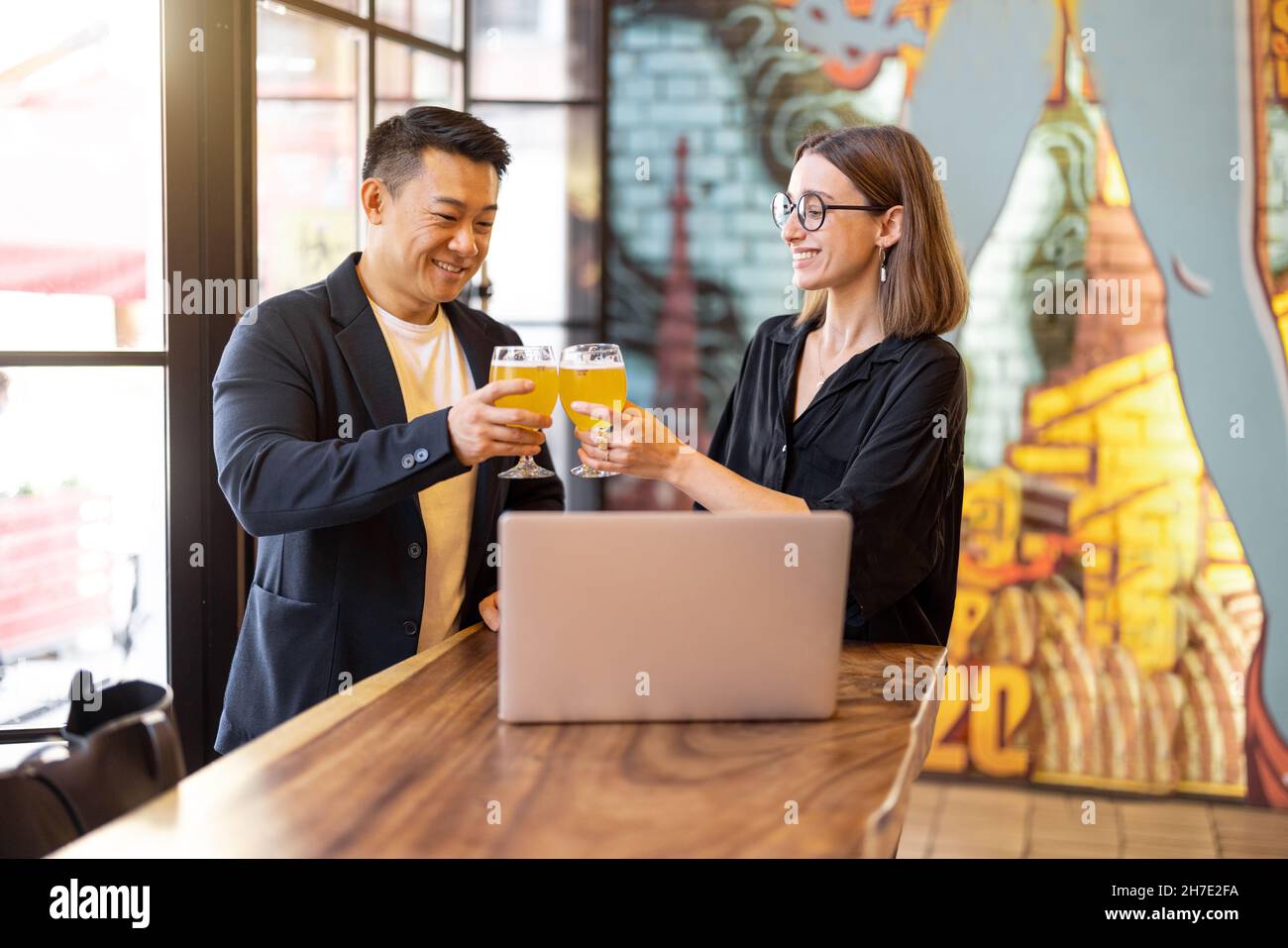 Gli amici parlano e bevono birra al bar Foto Stock