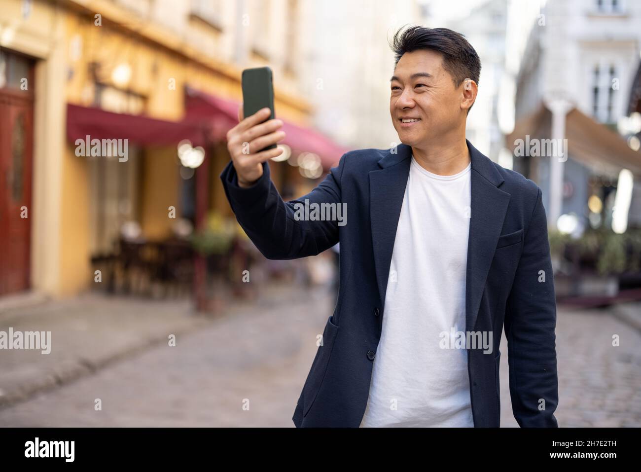 Uomo d'affari con telefono nella strada della città vecchia Foto Stock