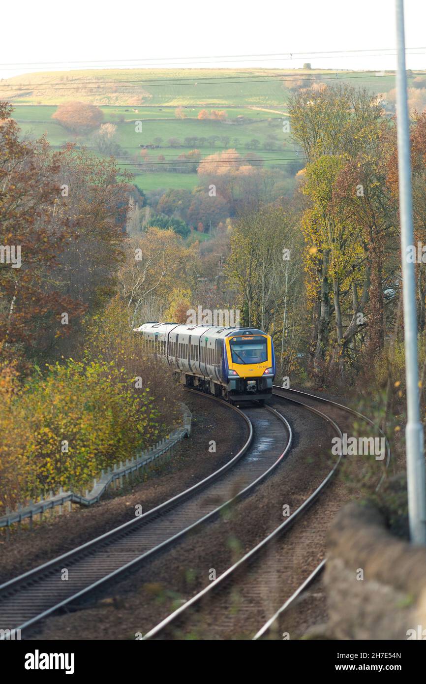 Un treno ferroviario del nord passa attraverso Calderdale accanto alla A58 strada principale di Leeds tra Halifax e Hipperholme nel West Yorkshire, Inghilterra, Regno Unito Foto Stock