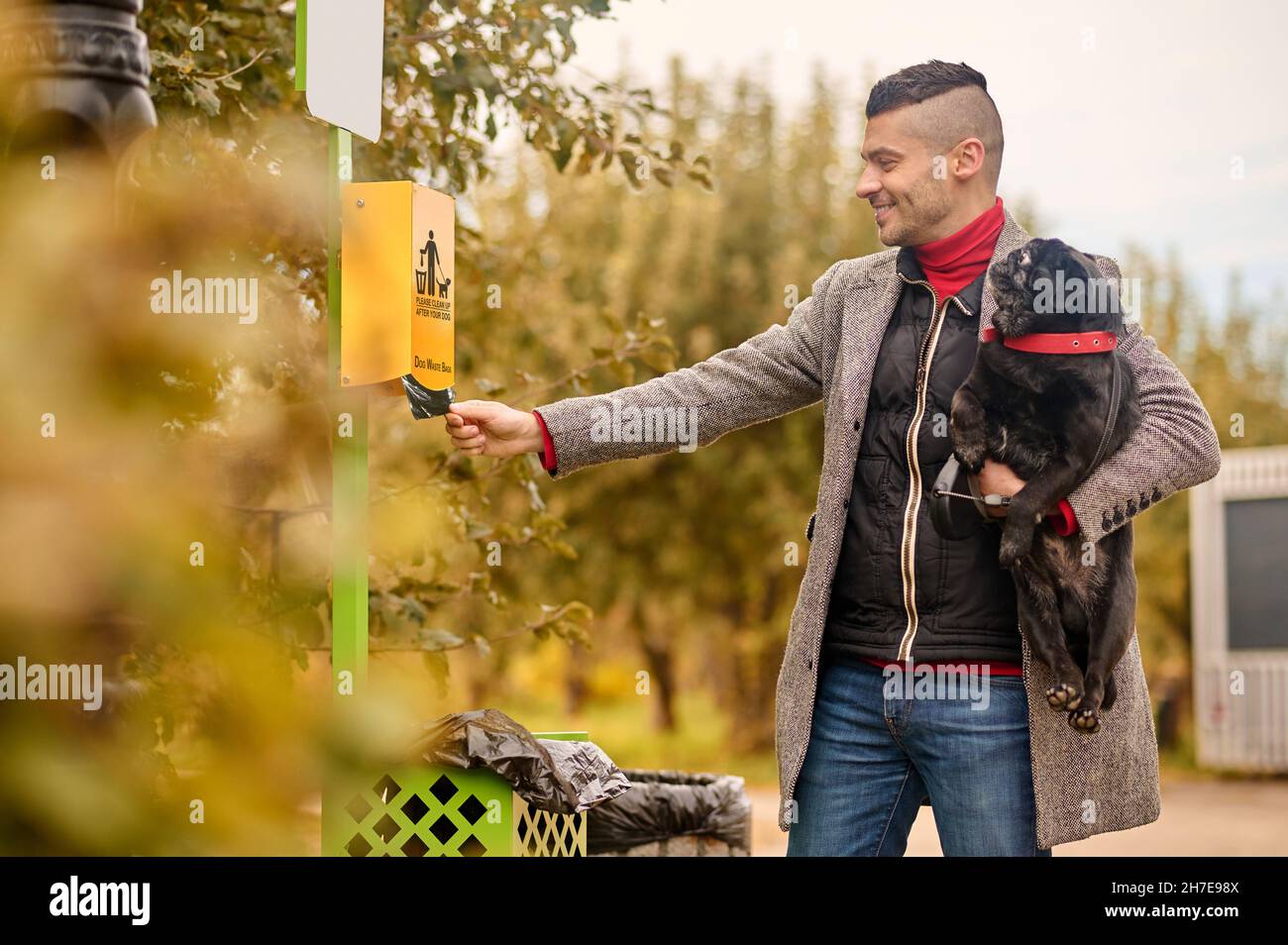 Un proprietario dell'animale domestico che prende il roba di pulizia dalla scatola Foto Stock