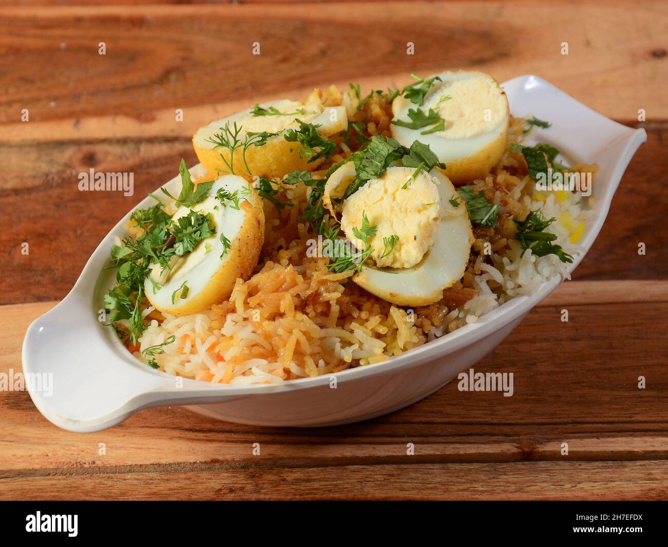 Uovo Biryani - riso Basmati cotto con masala e spezie e servito con uova sode a fette, fuoco selettivo Foto Stock