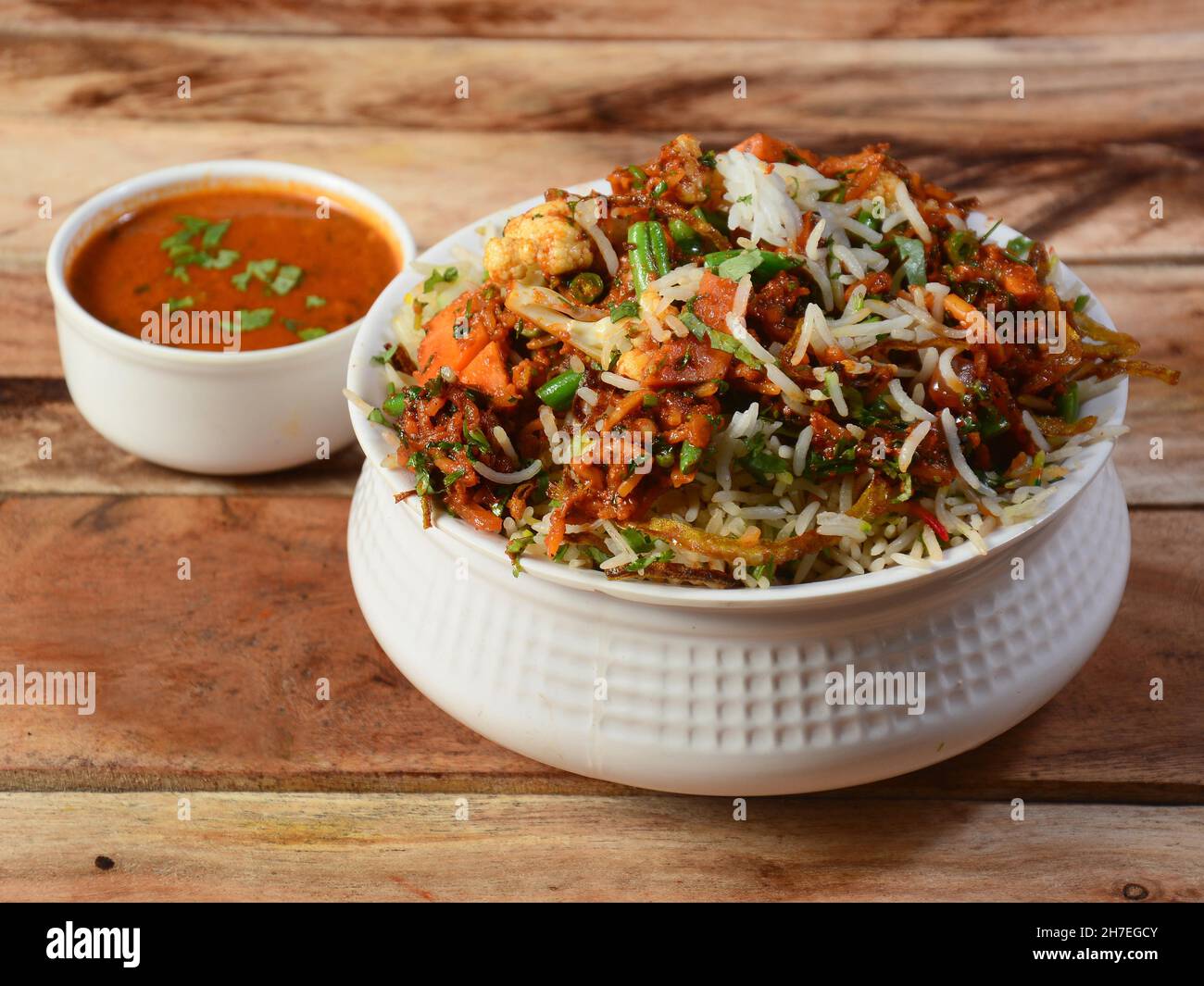 hyderabadi tradizionale vegetale / verdure dum biryani con verdure miste servite con curry, fuoco selettivo Foto Stock