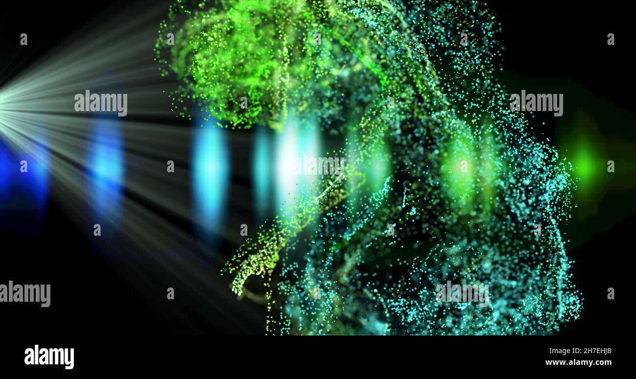 Immagine di particelle verdi e blu in fascio di luce bianco e luci blu su sfondo nero Foto Stock