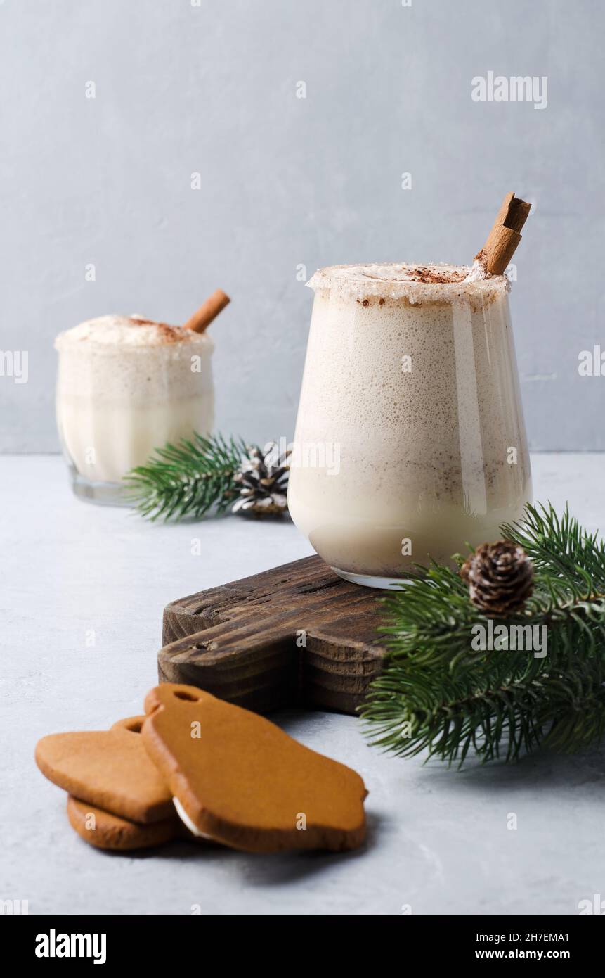 Melone con cannella e pan di zenzero naturale su sfondo grigio. Natale bevi il punch d'uovo con il liquore Foto Stock