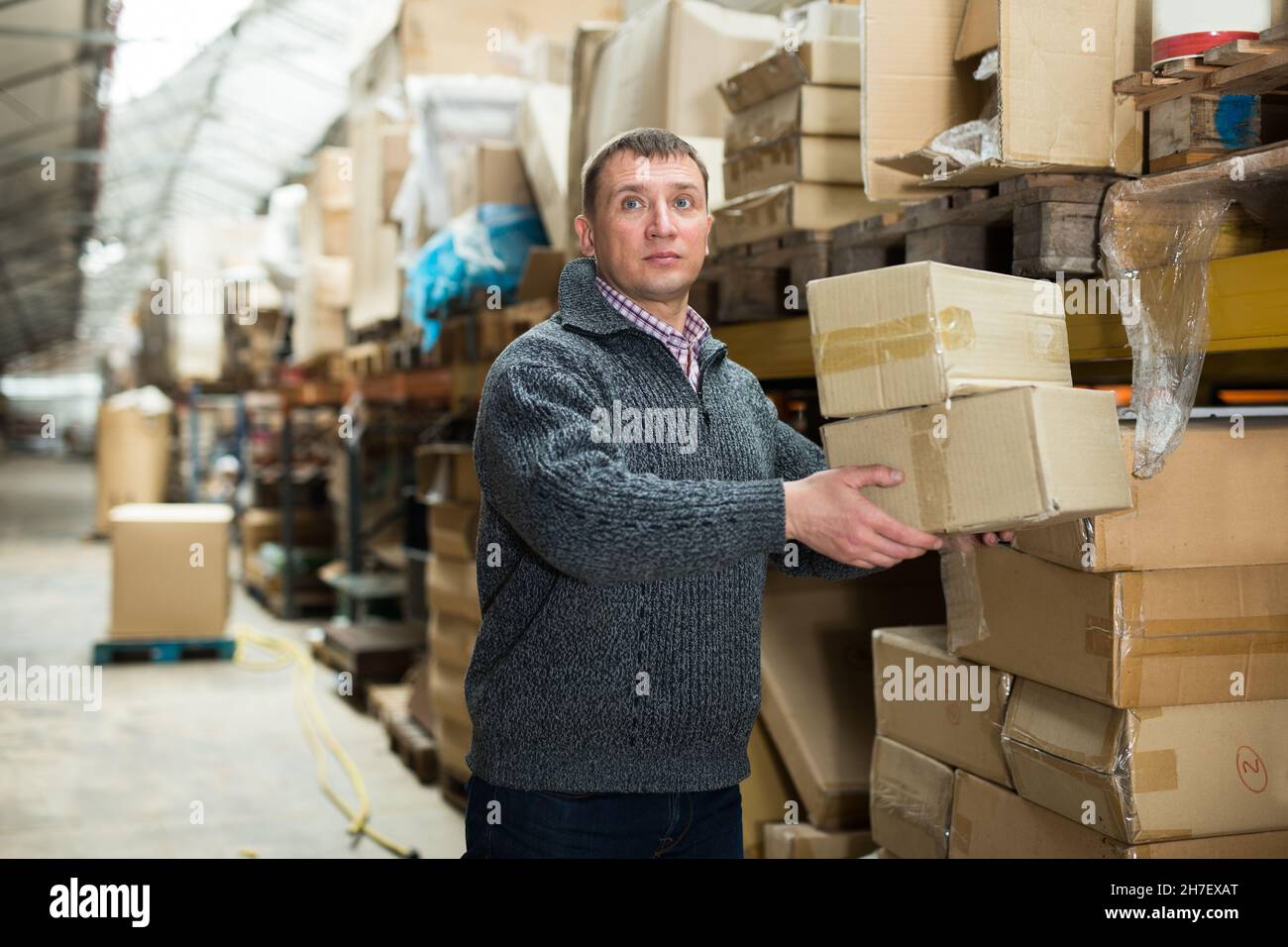 Uomo magazzino lavoratore che trasportano scatole Foto Stock