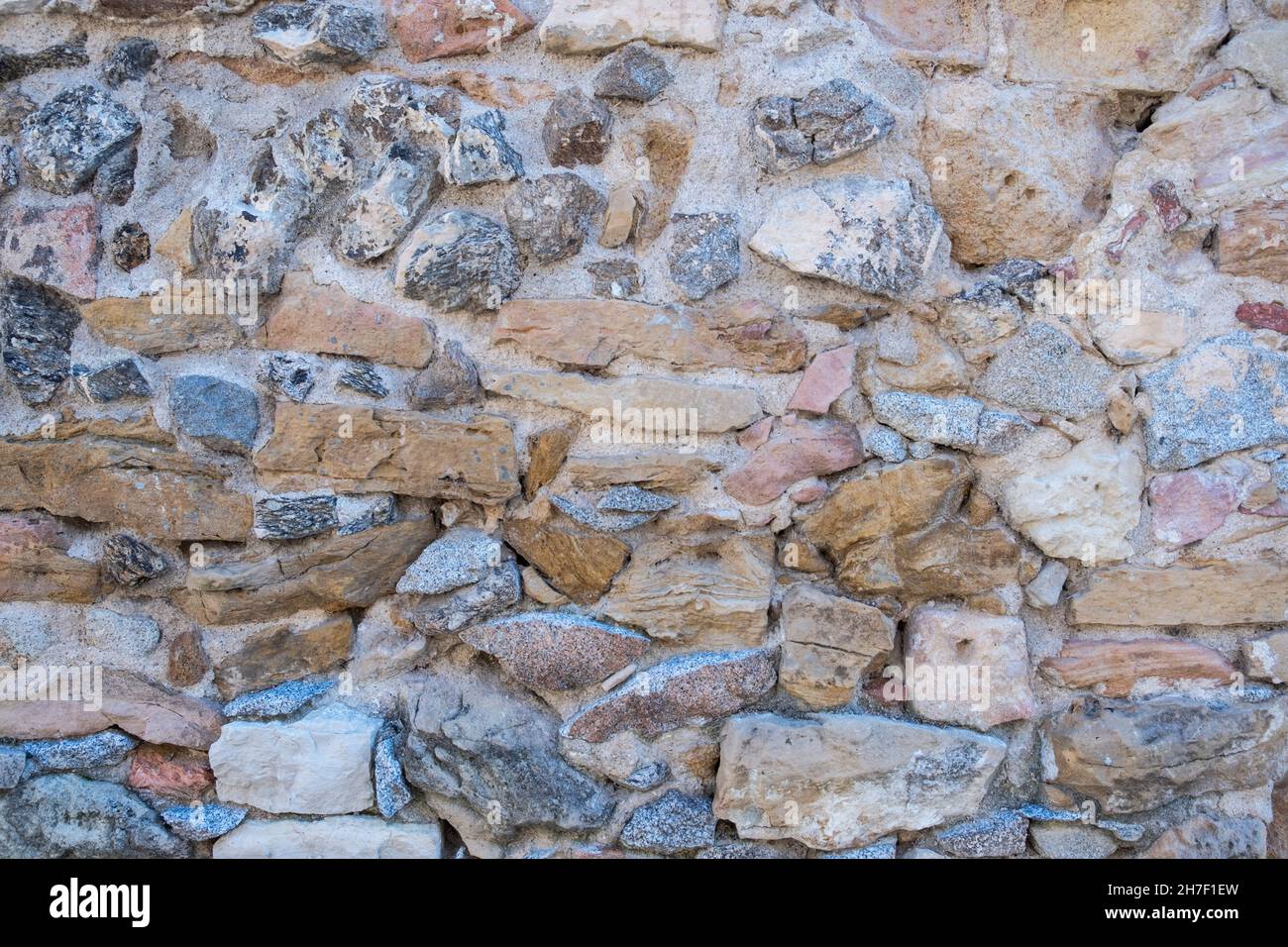 texture parete rustica di blocchi di pietra di diverse tonalità Foto Stock