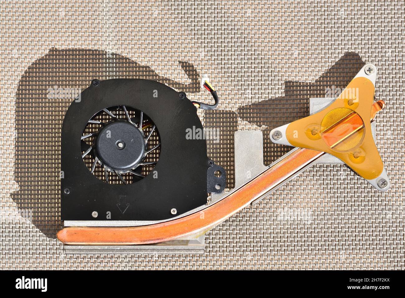 Ventola nera e arancione di un computer portatile illuminato dalla luce solare Foto Stock