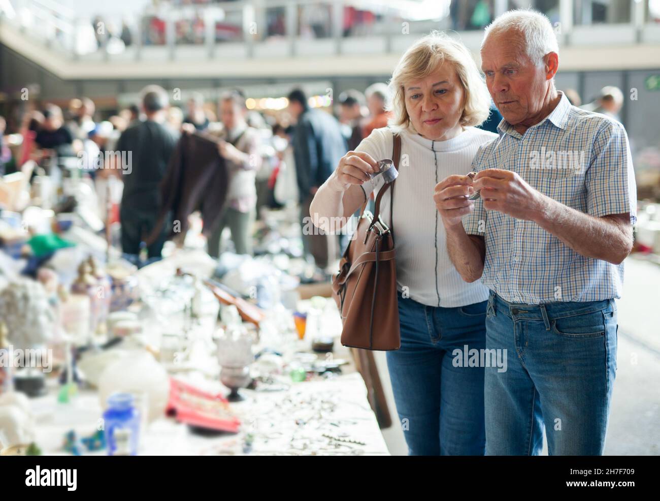 L'uomo e la donna anziani considerano le cose nel mercato delle pulci Foto Stock