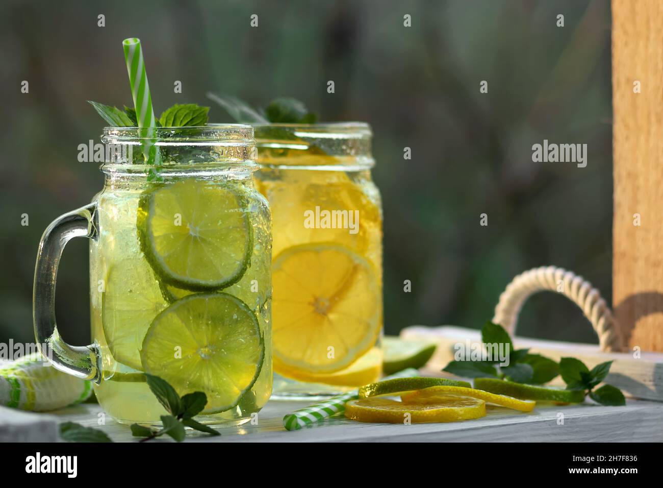 Fresca e rinfrescante limonata fatta in casa con menta, limone e lime in vasetti di muratore. Foto Stock