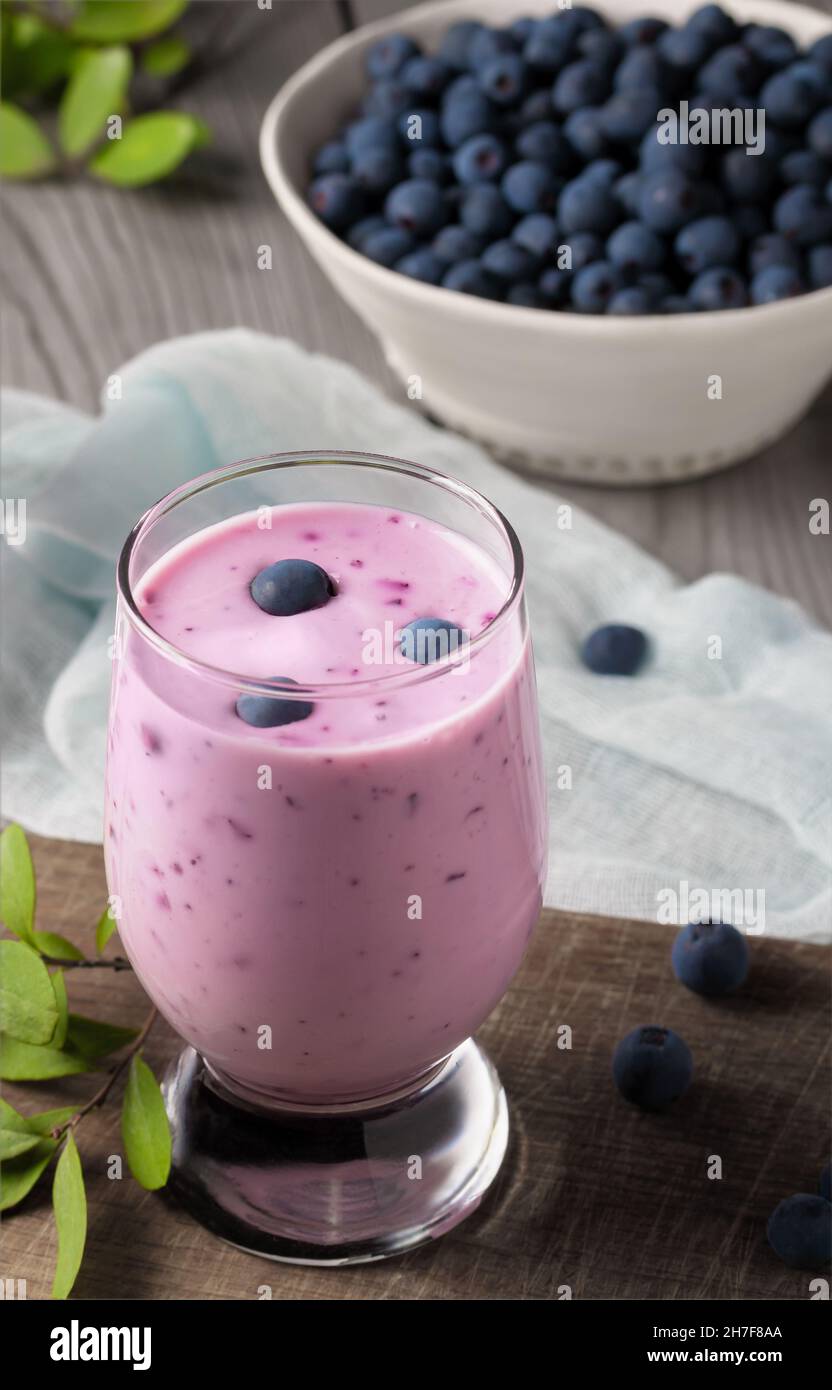 Frullato di yogurt ai mirtilli fatto in casa. Agitare le proteine con le bacche. Immagine verticale. Foto Stock
