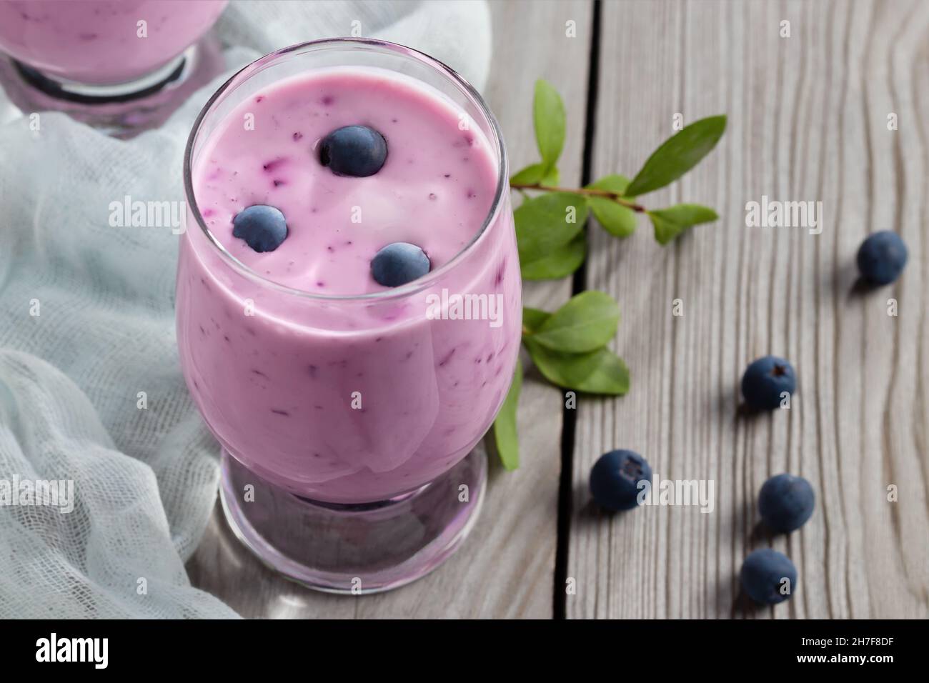 Frullato di yogurt ai mirtilli fatto in casa. Agitare le proteine con le bacche. Foto Stock