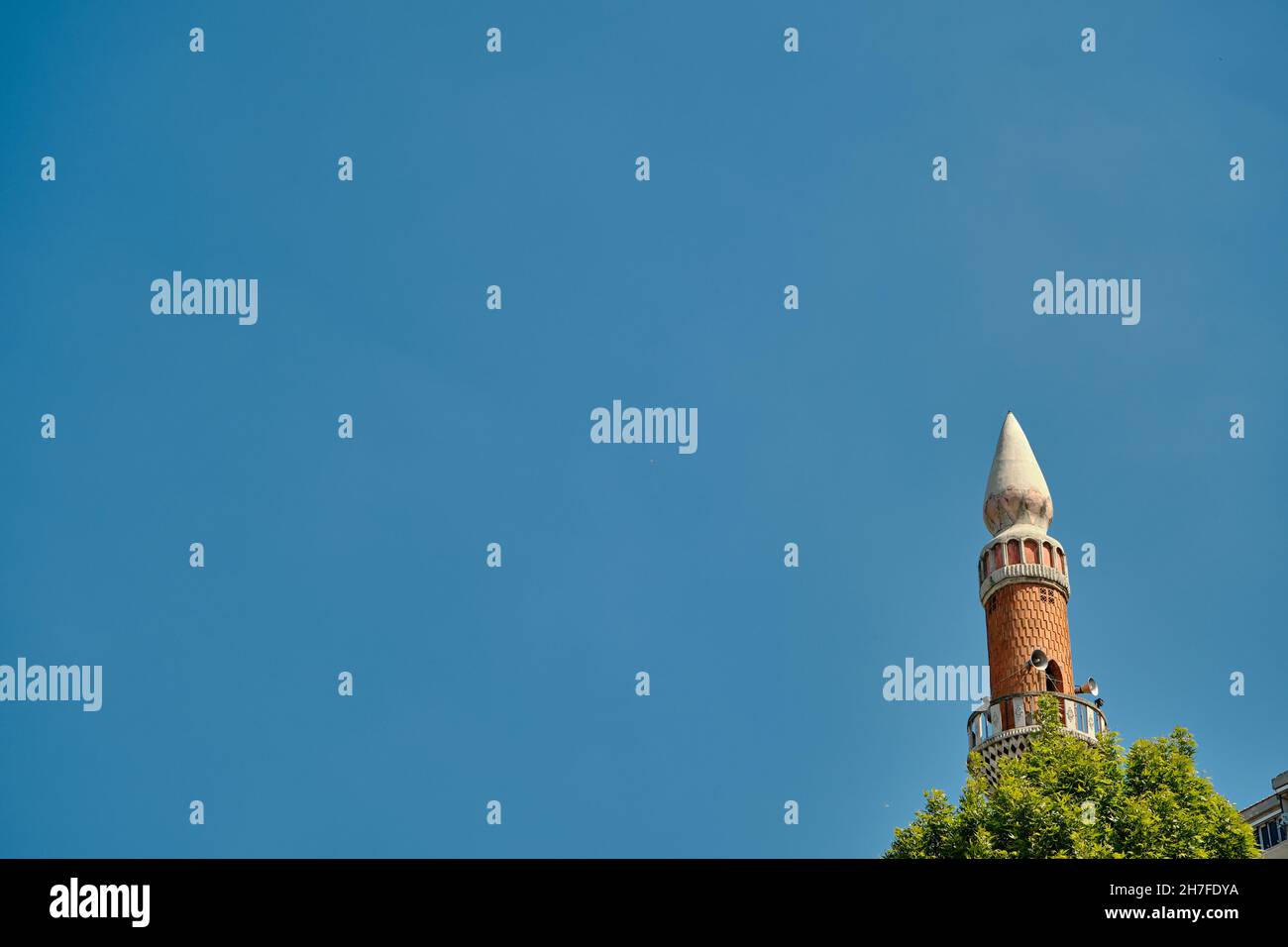 Architettura e cima del minareto e albero in Gemlik Bursa con cielo blu durante le giornate luminose Foto Stock