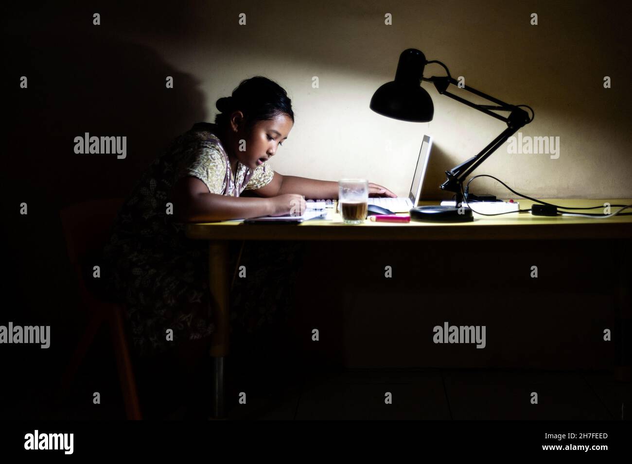 Ragazza della scuola indonesiana che fa il lavoro domestico. Foto Stock