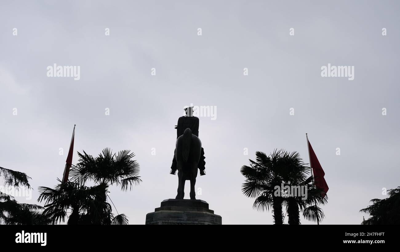 Scultura di Ataturk fondatore della Repubblica Turca nel centro di Bursa (heykel) durante il tempo piovoso e sovrastato con bandiera turca e scultura coperta Foto Stock