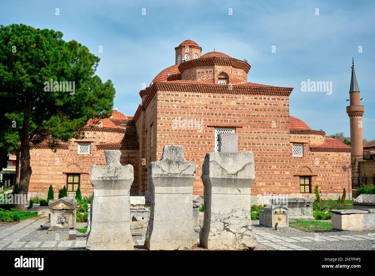 iznik, Turchia. Museo d'arte islamica, muro di mattoni rossi, minareto di moschea e giardino d'esposizione con ghiaia terra antiche tombe marmo pietra rovina romana Foto Stock