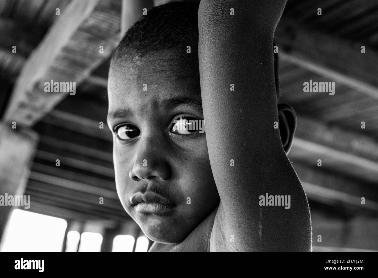 Un bambino curioso che guarda direttamente nella macchina fotografica al villaggio di Keapara, distretto di Rigo, provincia centrale, Papua Nuova Guinea. Foto Stock
