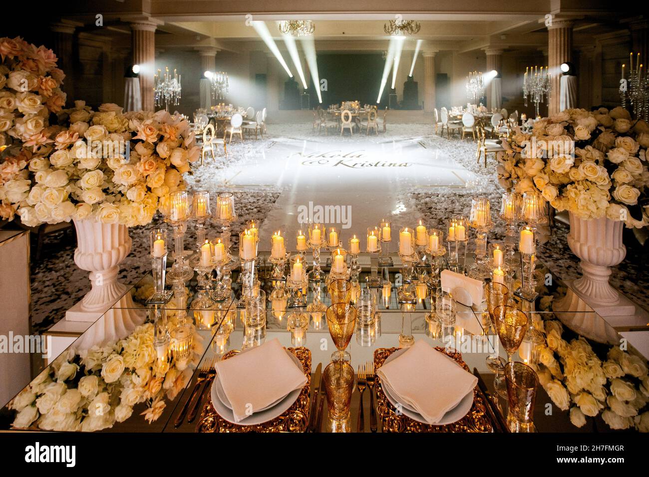 Sala per matrimoni con palco per matrimoni decorato con fiori freschi e candele Foto Stock