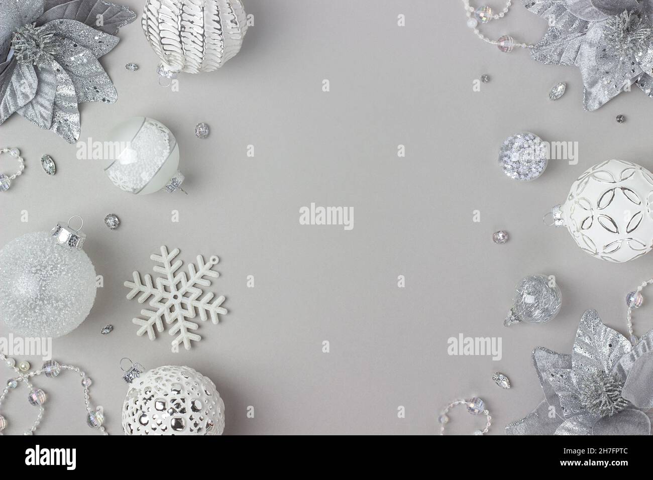 Cornice vacanza in argento e bianco lucido decorazioni natalizie su sfondo grigio. Buon Natale, Natale e Capodanno. Vista dall'alto, Flat Lay, Co Foto Stock