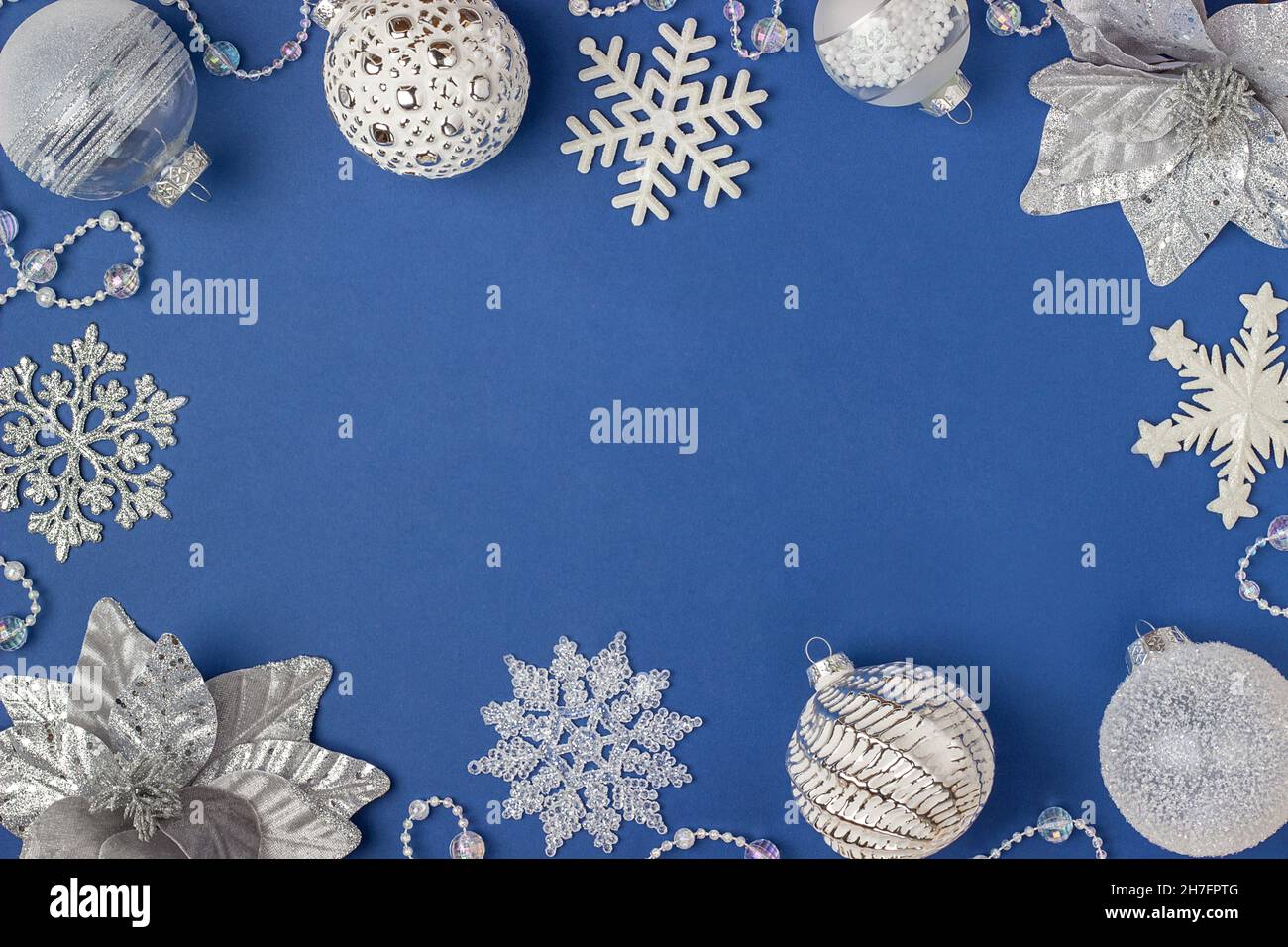 Cornice vacanza in argento e bianco lucido decorazioni natalizie su sfondo blu. Buon Natale, Natale e Capodanno. Vista dall'alto, Flat Lay, Co Foto Stock