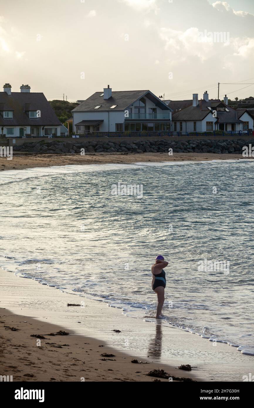 Una donna che sta per entrare va a nuotare a Trearddur Bay, Holy Island, Anglesey, Galles Foto Stock