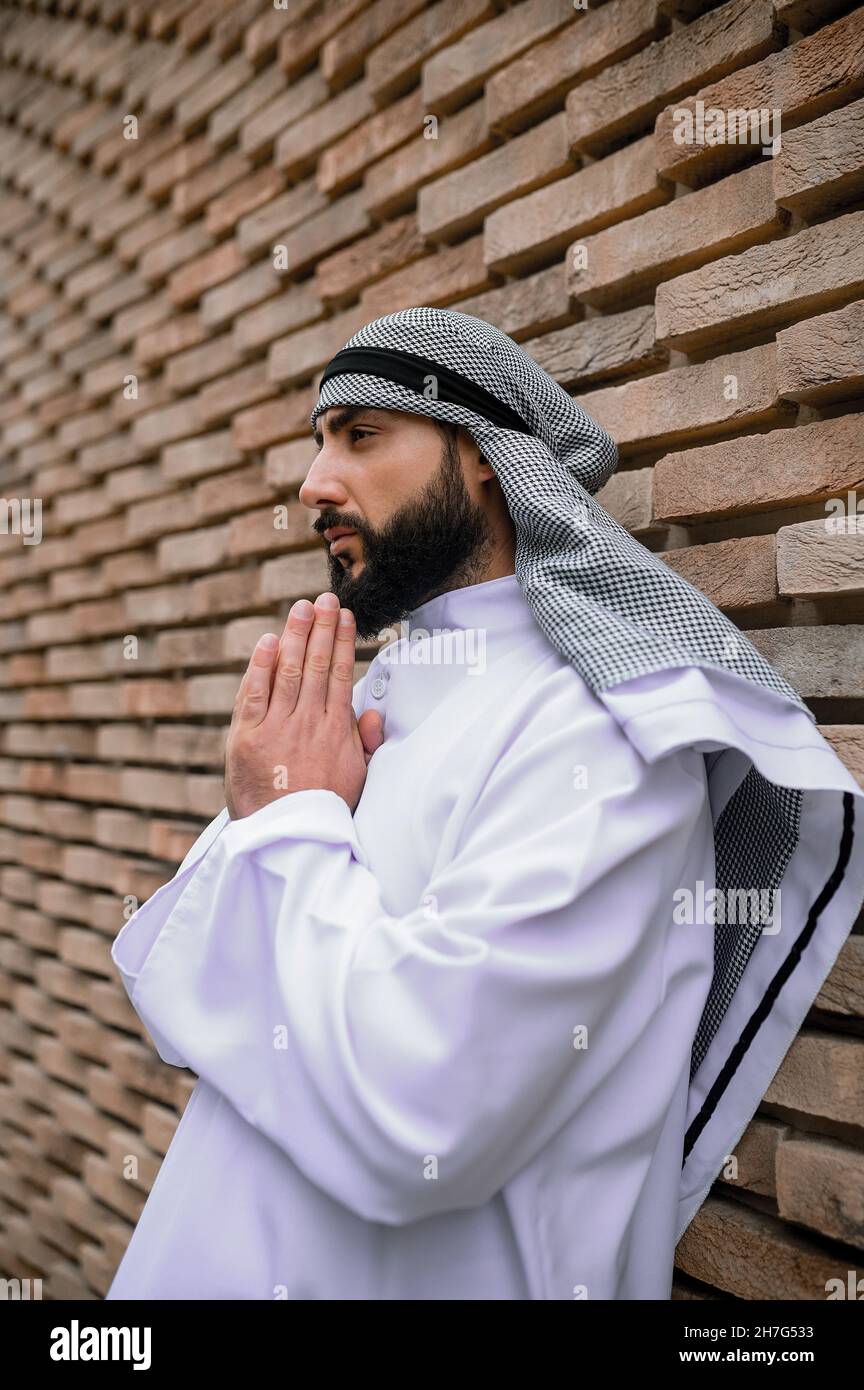 Giovane uomo arabo che prega e guarda concentrandosi Foto Stock