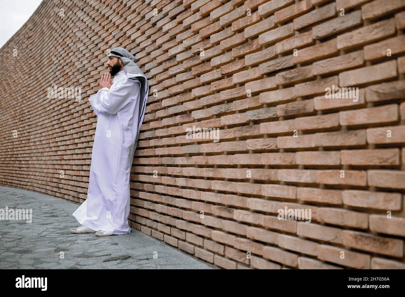 Giovane uomo arabo che prega e guarda concentrandosi Foto Stock