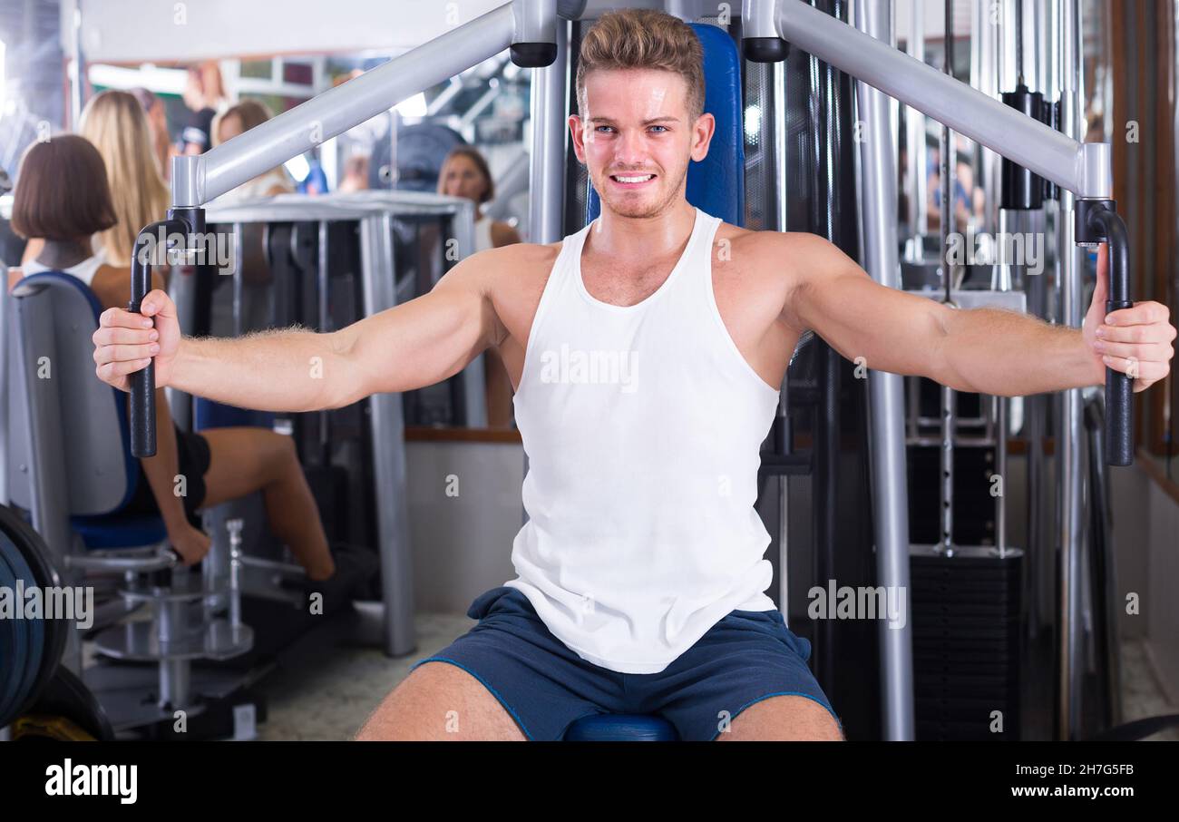 uomo ben addestrato che utilizza pec coperta palestra macchinari interni Foto Stock