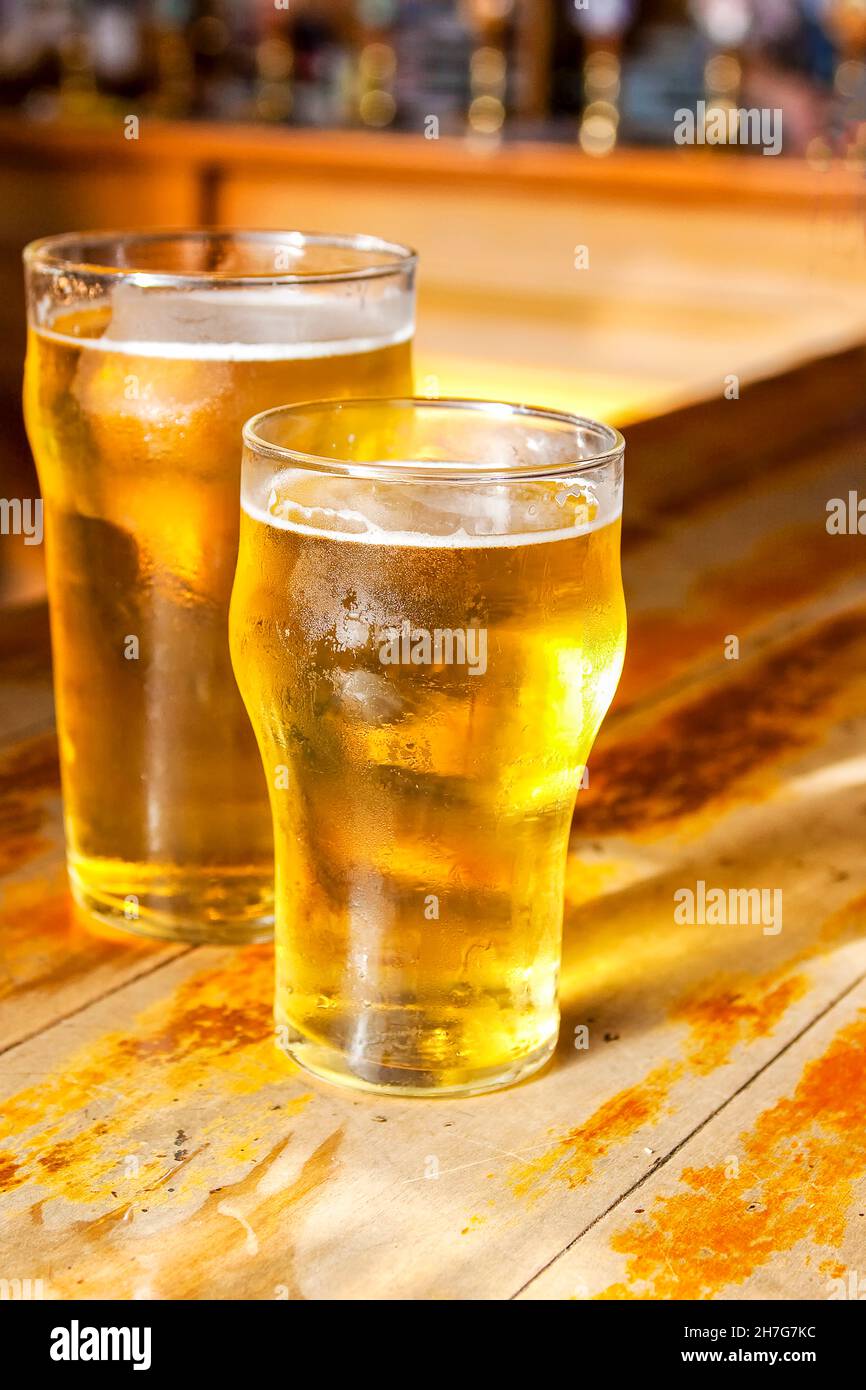 Due birre dorate chiare su un bar in legno Foto Stock