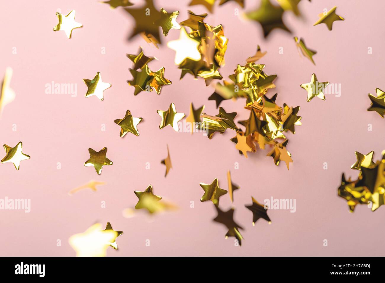 Sfondo con stelle volanti a base di confetti d'oro. Sfondo rosa. Sfondo  Foto stock - Alamy