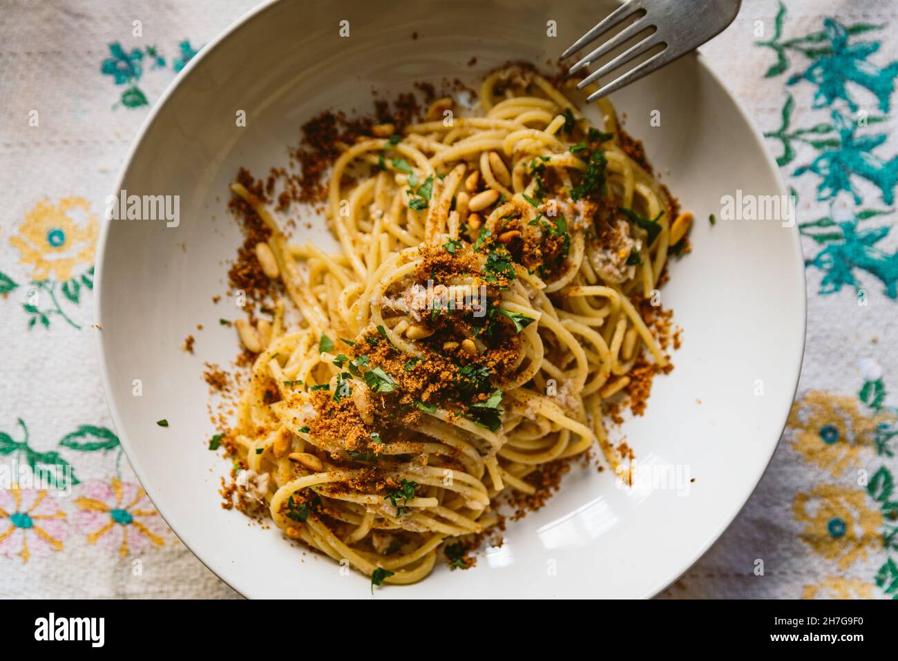 piatto di pasta italiana fatto in casa noto come "pasta con le sarde" su un panno da tavola, realizzato con spaghetti, sardine, prezzemolo, pinoli e pangrattato. I classico Foto Stock