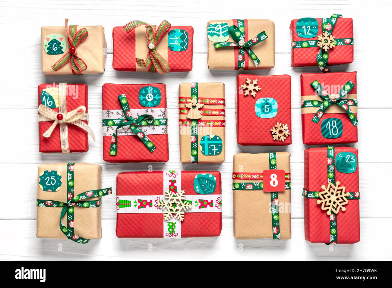 Scatole regalo rosse, verdi e confezionate a mano decorate con nastri,  fiocchi di neve e numeri, decorazioni natalizie e decorazioni su tavola  bianca Natale avvento cale Foto stock - Alamy