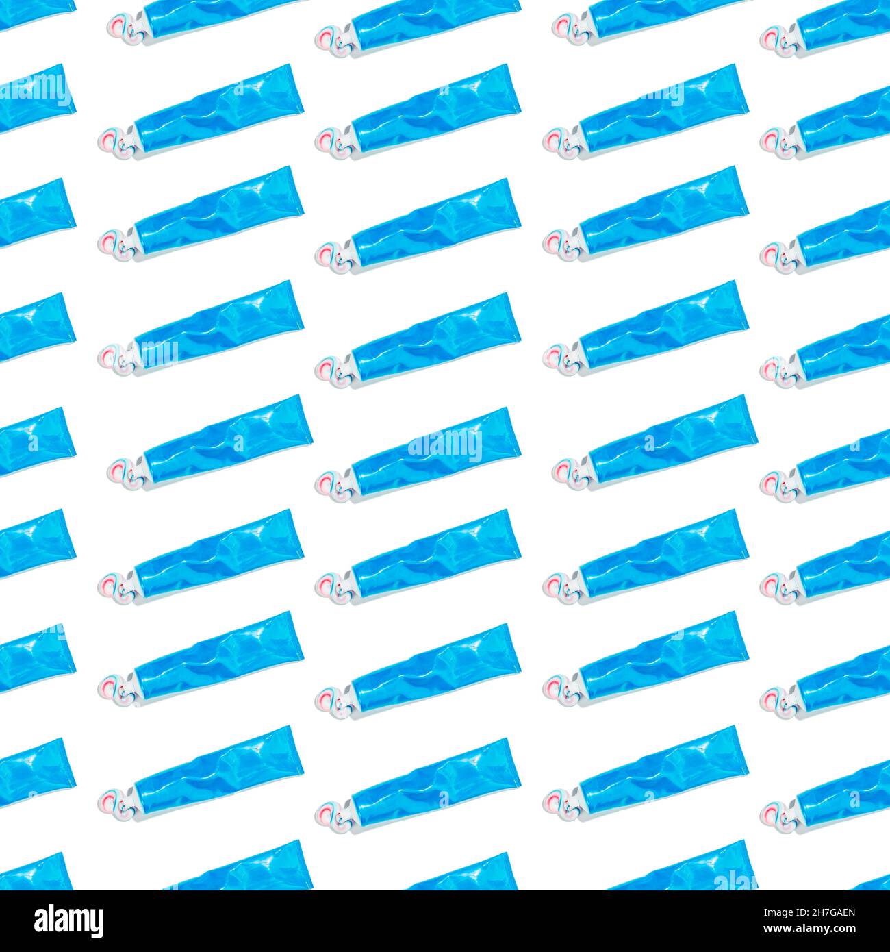 Molti tubi blu di dentifricio con dentifricio rosso e blu spremuto su sfondo bianco. Ripetizione senza giunture Foto Stock