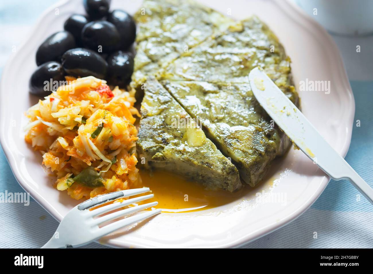 Tortilla di patate con spinaci con insalata di verdure e olive nere Foto Stock
