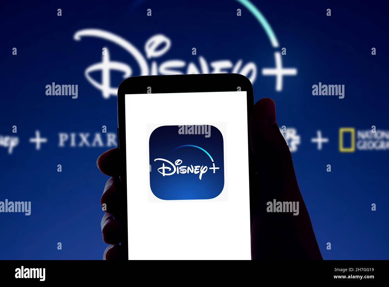 Il logo Disney streaming app Disney+ è visto sullo schermo di un telefono cellulare e la visualizzazione di un portatile a Barcellona, in Spagna, il 16 novembre 2021 Foto Stock
