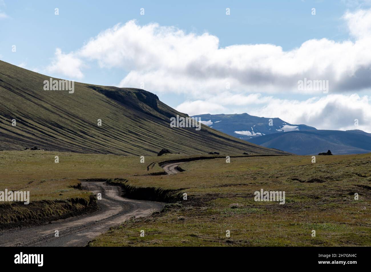 Vista panoramica sull'altopiano con strada sterrata vicino al vulcano Katla in Islanda con montagne sullo sfondo un cielo bianco nuvoloso blu Foto Stock