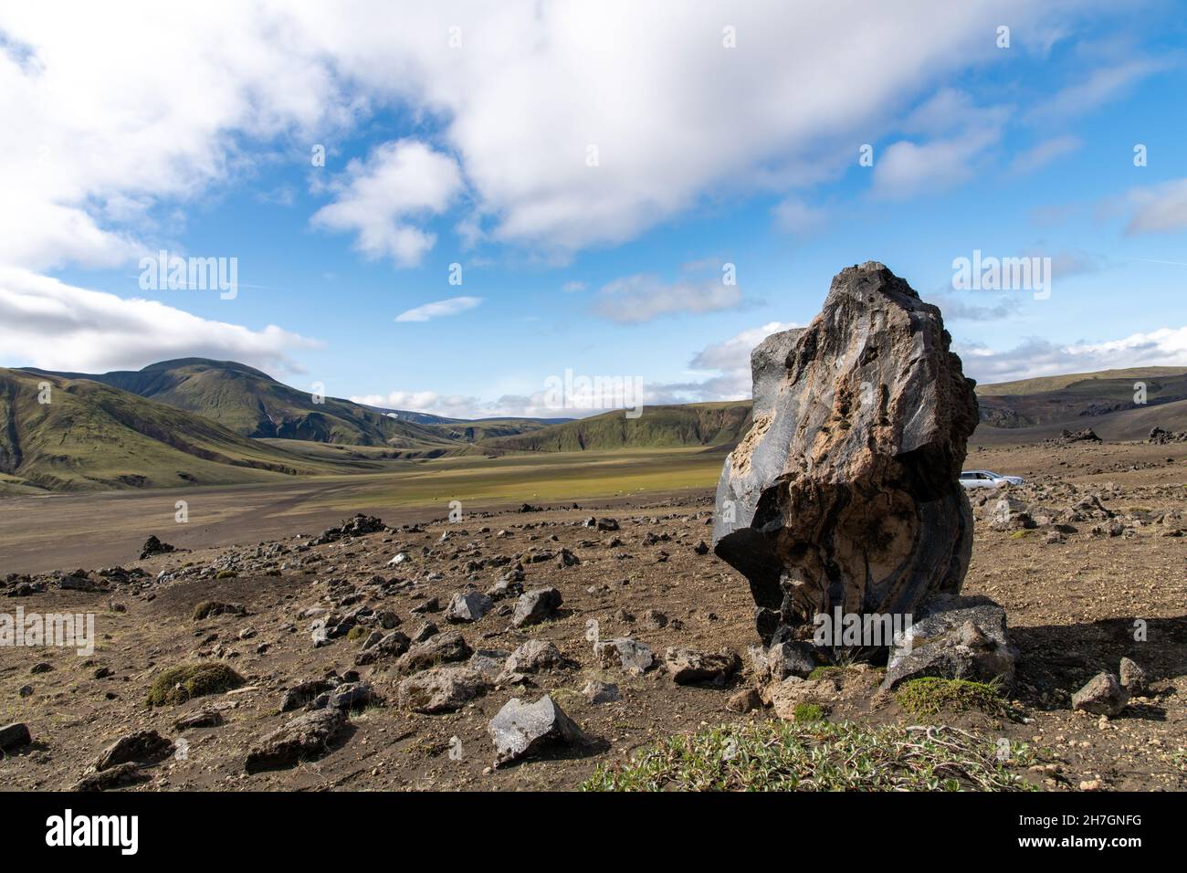 Primo piano di un pezzo di pietra basaltica con vista panoramica ad alto angolo sull'altopiano vulcanico vicino al vulcano Katla in Islanda Foto Stock