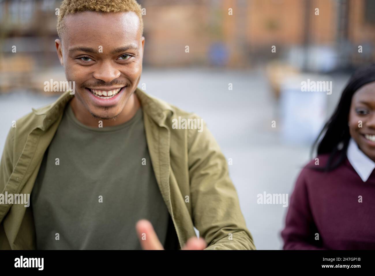 Ritratto di un giovane ragazzo ispanico sorridente che si diverte al campus universitario Foto Stock