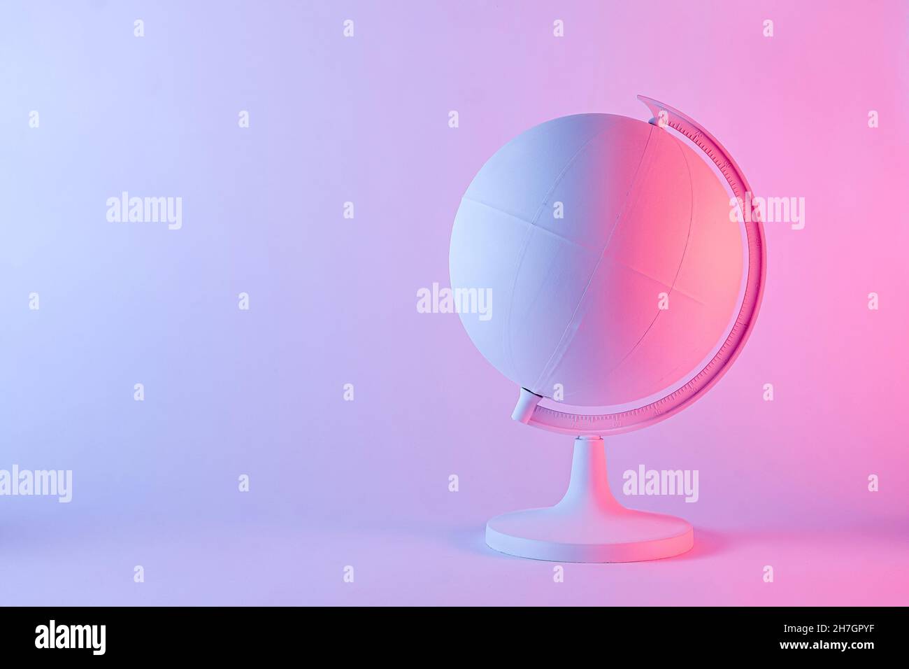 Modello di un globo con mappa vuota in luce sfumata rosa e viola. Concetto di geografia con spazio di copia Foto Stock