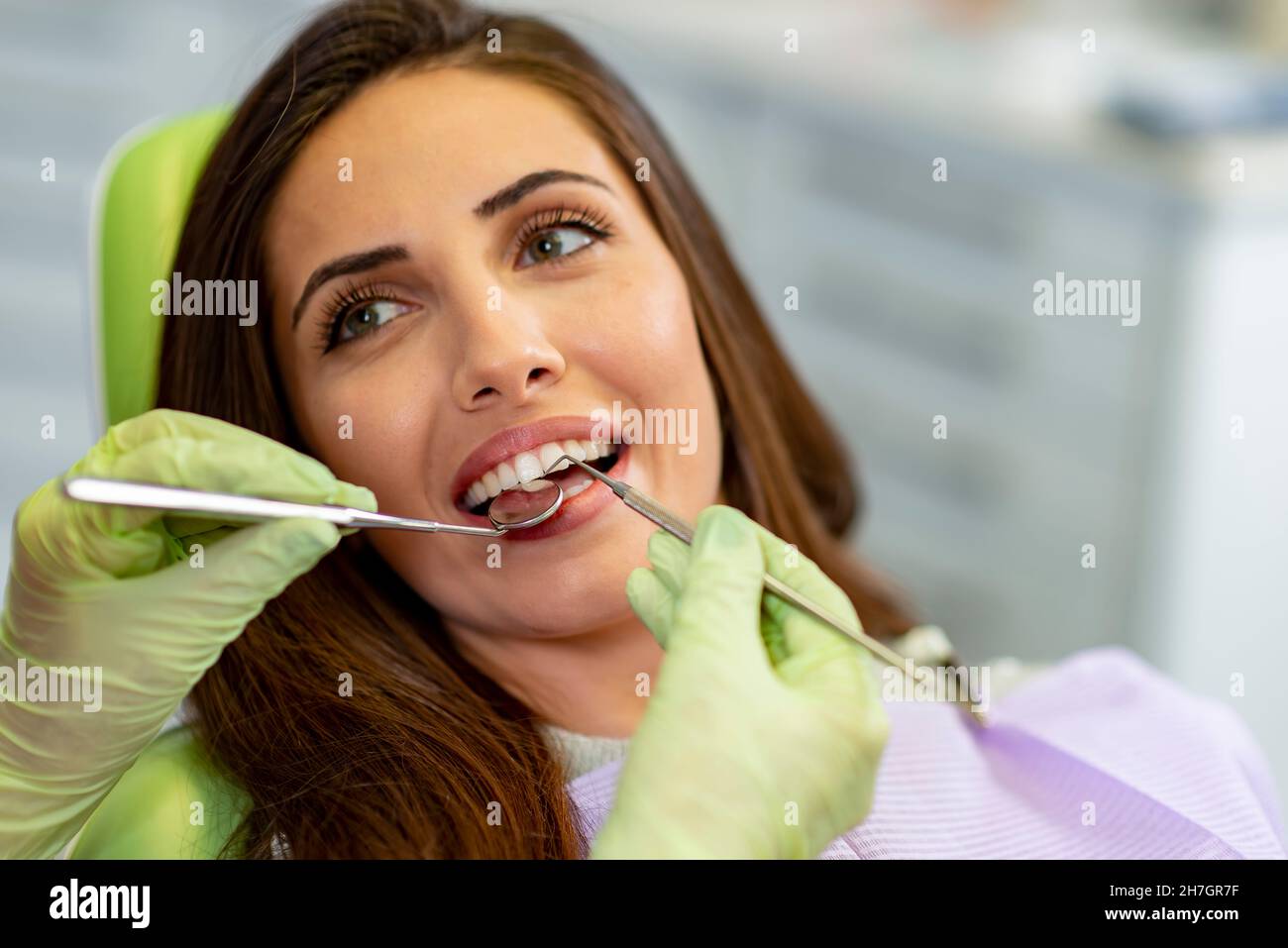 Sorridente giovane donna alla sedia dentista Foto Stock