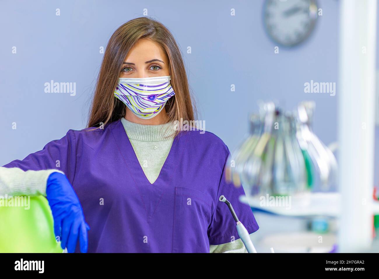 Giovane dentista femminile che tiene gli attrezzi dentali nella sua clinica Foto Stock