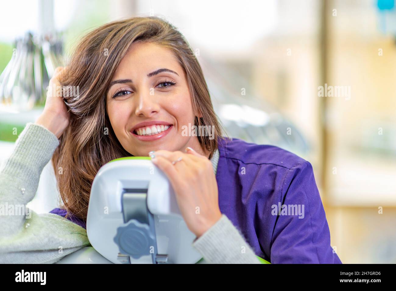 Giovane donna sorridente alla sedia dentista Foto Stock