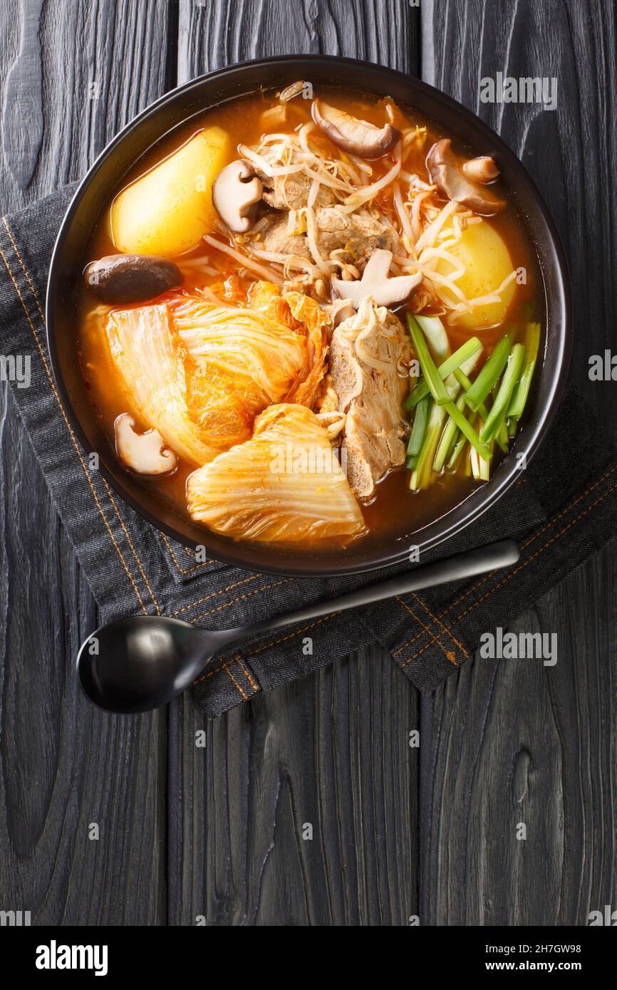 Zuppa coreana di ossa di maiale Gamjatang da vicino nella ciotola sul tavolo. Vista dall'alto verticale Foto Stock