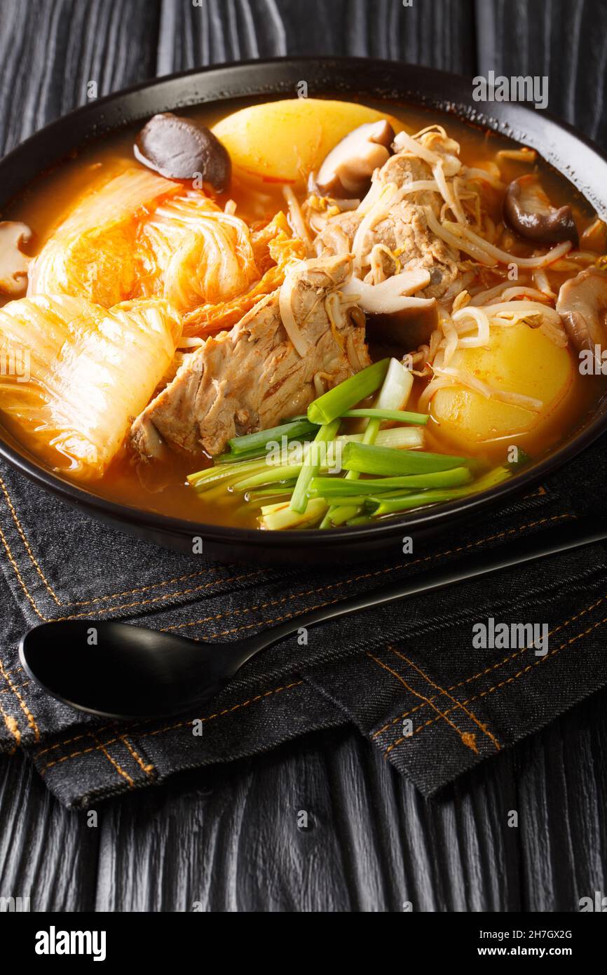 Zuppa coreana di ossa di maiale Gamjatang da vicino nella ciotola sul tavolo. Verticale Foto Stock