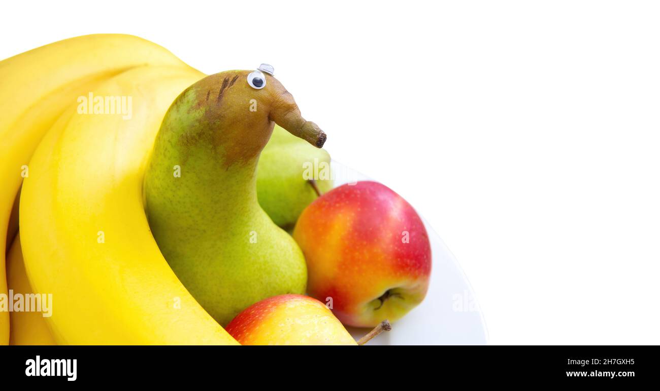 Ritratto di un divertente personaggio antropomorfo di pera con occhi googly su un piatto di frutta Foto Stock