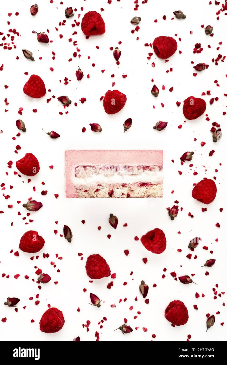 Vista dall'alto della deliziosa fetta di torta di mousse di litchi e lamponi con gli strati visualizzati e gli ingredienti della ricetta disposti su sfondo bianco. Menu del ristorante e concetto di pasticceria in stile piatto. Foto Stock