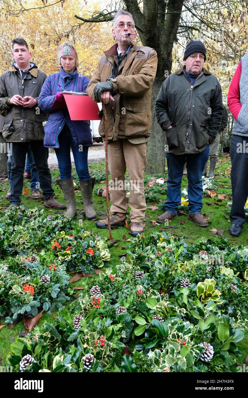 Tenbury Wells, Worcestershire, UK - Martedì 23 Novembre 2021 - Auctioneer Nick Champion guida l'asta annuale di Natale Holly e Mistletoe a Burford House - l'asta è in esecuzione da oltre 160 anni e attrae fioristi e commercianti di mercato da tutto il Regno Unito e comprende le corone preparate così come i fasci sciolti di agrifoglio e di vischio. Foto Steven Maggio / Alamy Live News Foto Stock