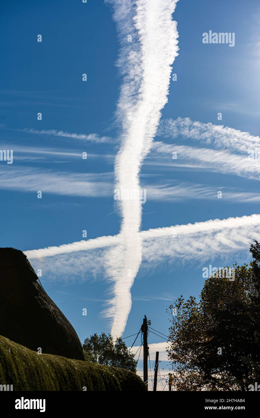 Contrails, o piste a getto di condensa da aerei, in un cielo blu sopra Hampshire, Regno Unito Foto Stock