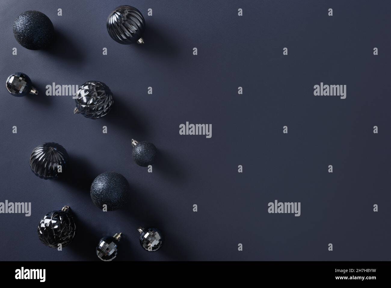 Baubles blu Natale su sfondo bianco e nero. Vista dall'alto. Spazio di copia. Biglietto di auguri di Natale. Foto Stock